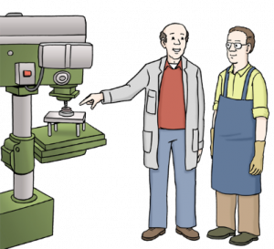 Das Bild zeigt zwei Männer in Arbeitskleidung, die neben einer Arbeitsmaschine stehen. En Mann erklärt dem anderen etwas.