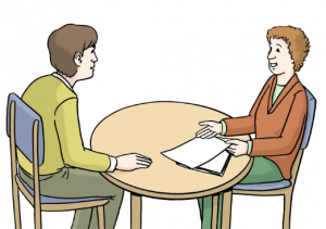 Das Bild zeigt zwei Personen, die an einem runden Tisch sitzen. Eine Person hat Zettel vor sich liegen und erklärt der anderen Person etwas.